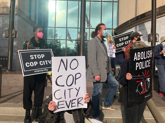 Protesters hold signs against Cop City in Atlanta.