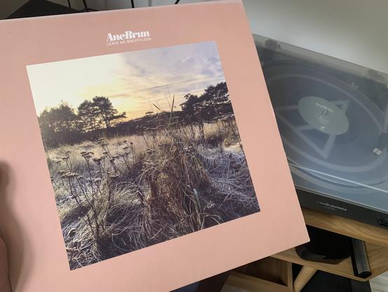 LP cover of Ane Brun’s Leave Me Breathless album. Record player with the transparent vinyl playing in the background.