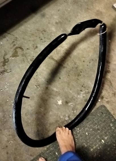 A bicycle inner tube holding air pressure, with constrictor knots tied either side of a large gash.