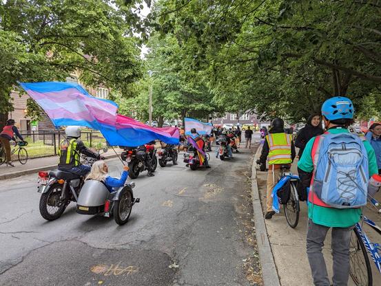 Start of the parade behind the motorcycles (including one with a sidecar) with pride flags flowing