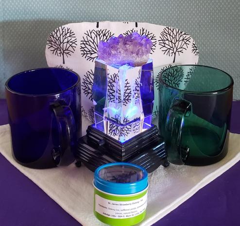 A tea tableau in deep ocean colors with a lighted crystal at center etched with a lighthouse design.