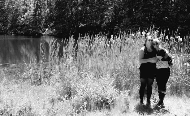 Talia & Lyrica by the cattails beside the lake. Monochrome.