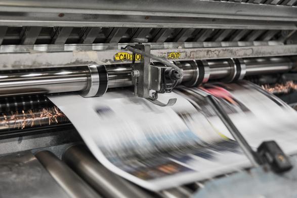 Zu sehen ist das Innere eines Druckers, in dem gerade eine Zeitung gedruckt wird. Foto: Bank Phrom