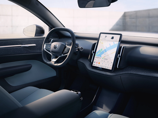Interior photo or rendering of a Volvo EX30 battery electric vehicle showing a the dashboard with a steering wheel in left-hand drive setup and a large tablet in the middle with controls for everything