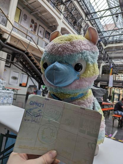 Das Reisealpaka sitzt im Lichthof 3 der HfG und zeigt stolz seinen gestempelten Hackspace-Passport