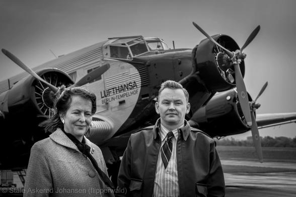 Two people in front of an aircraft. Black and white.