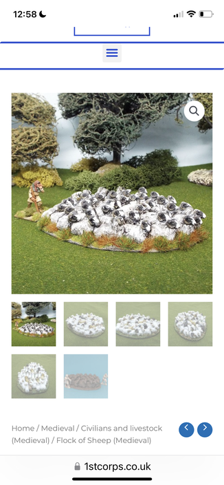 Miniature diorama of a flock of sheep, medieval shepherd, trees and rocks.