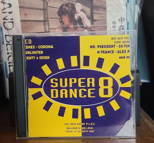 Image shows a CD case. Front cover shows multiple artist names like Corona, Mr. President, N-Trance, Bolland & Bolland. The graphic design shows 4 quadrants and there is an oval with rectangles around it in the center circling Super Dance 8 text