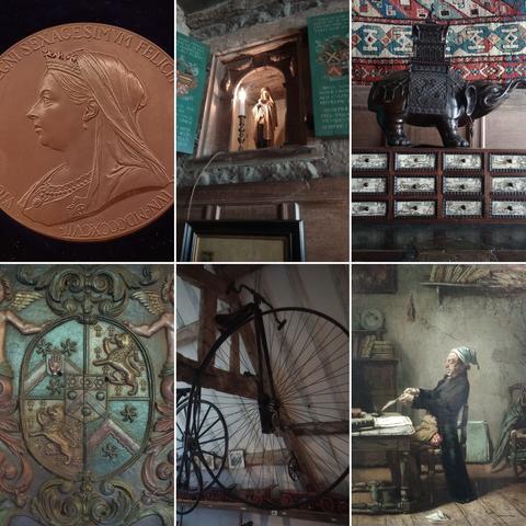 Six items inside Snowshill Manor. A golden Queen Victoria coin, a religious statuette in an alcove, an ebony elephant over a set of drawers, a coat of arms, a suspended penny farthing bicycle, and an 18th century oil painting of a man sat at a desk