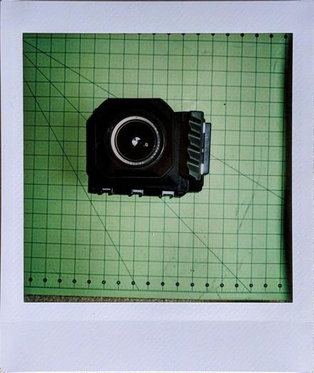 instax photo of an Instax camera assembled from a mamiya press 75mm lens, additive manufactured body, and lomograflok Instax wide back