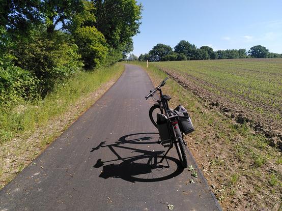 Auf dem Bild ist ein auf einem neuen Radweg abgestelltes Fahrrad zu sehen. Das Foto entstand auf dem neuen Radweg zwischen Felm und Felmerholz.