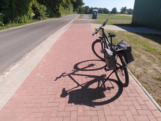 Auf dem Bild ist ein auf einem neuen Radweg abgestelltes Fahrrad zu sehen. Das Foto entstand auf dem neuen Radweg in Felm.