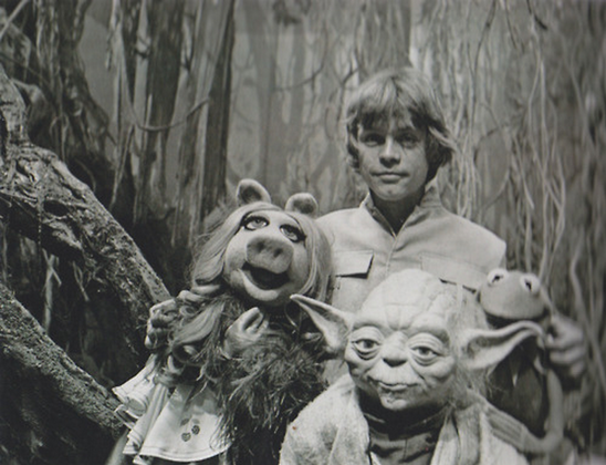 Black and white picture of Luke Skywalker, Yoda, Miss Piggy and Kermit the frog all posing together.