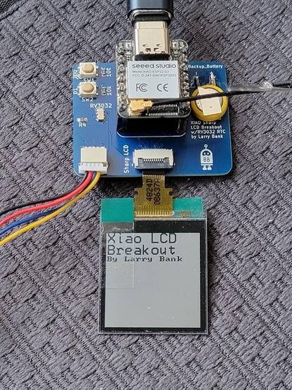 Xiao breakout PCB with ESP32-S3 connected to a 128x128 Sharp Memory LCD.