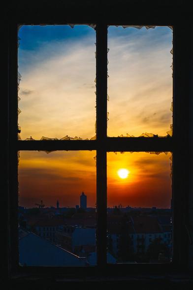 Sonnenuntergang: kräftige rote Farben
Blick durch ein zerbrochenes Fenster.
Die Skyline von Leipzig mit dem Uniriesen und einigen Baukränen.