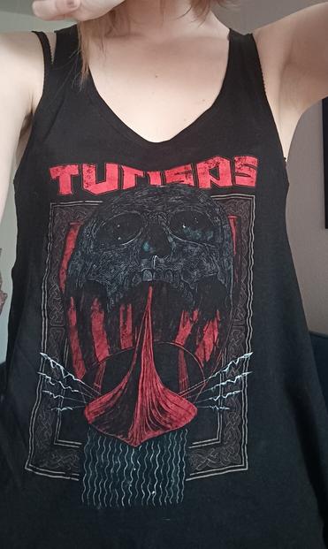 Langes Turisas-Top: roter Schriftzug des Bandnamens, darunter ein riesiger schwarzer Totenkopf, aus dessen Unterkiefer eine Galeere fährt. Unter der Galeere strömt Wasser nach unten. Die Szenerie ist eingefasst von einem Rahmen mit keltischen (?) Knoten.