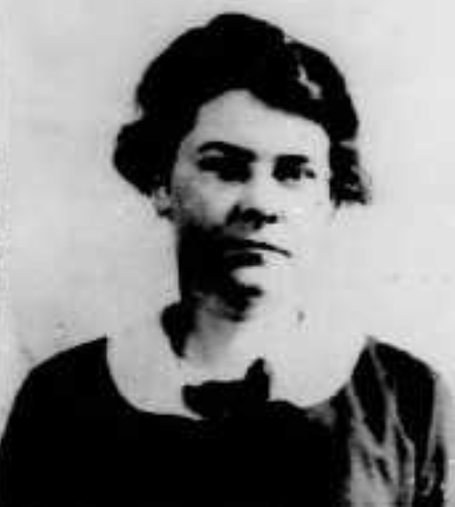 Katherine G. Ecob's 1922 passport photo; a white woman with short dark hair, wearing a dark top with a round white collar