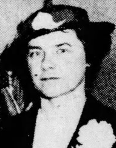 Katherine G. Ecob, from a 1935 newpaper photo; a white woman wearing a black brimmed hat, and a dark jacket, with a corsage on the lapel