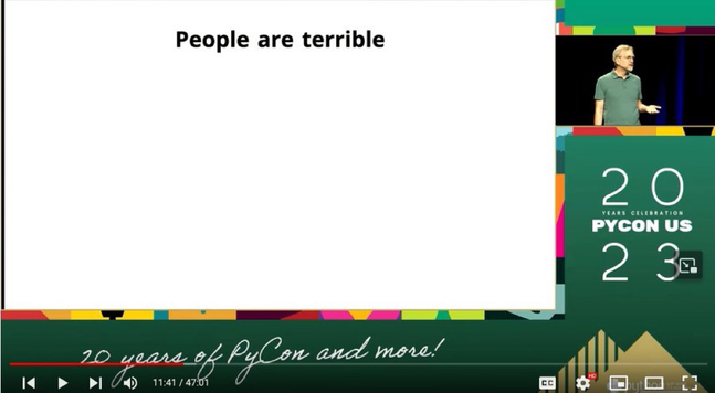 A PyCon US 2023 slide with a thumbnail view of Ned Batchelder presenting. The slide is all white and says in black text "People are terrible"