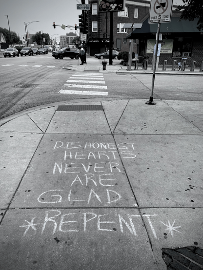 at a busy intersection in the rogers park neighborhood of chicago, written on the sidewalk in chalk “dishonest hearts never are glad *repent*”
