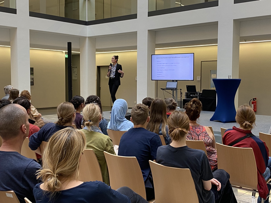 PD Dr. Verena Tscholl hält einen Vortrag auf einer Bühne.