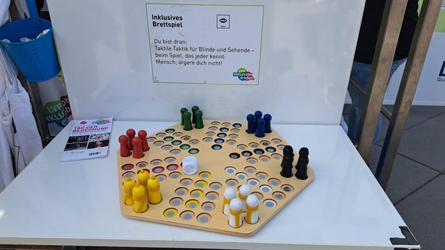 Zu sehen ist ein mensch ärger dich nicht spielen welches mit taktiler Taktik versehen ist so dass es für Menschen die auf diese angewiesen sind, einfacher ist dieses Spiel zu verwenden