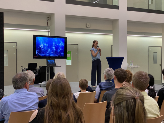 Dr. Antonia Groneberg steht auf der Bühne und hält einen Vortrag.