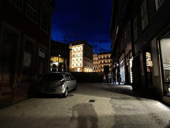 Fachadas de edifício comercial de 4 andares no Porto, à noite, com 28 janelas, cada uma circundada por 32 lâmpadas LED ligadas. O edifício destaca-se dos restantes pelo intenso brilho e poluição luminosa.