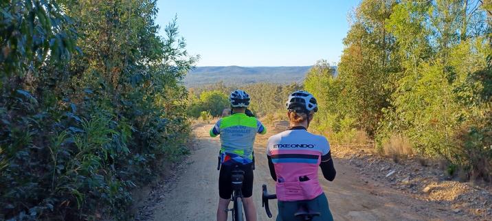 Two bike riders are taking pictures of the view from the course's highest point.