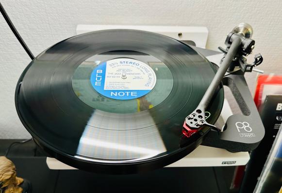 Photo of a record spinning on a turntable. 

The blue and white centre label reads, ‘Blue Note’.

The tonearm is extended and tracing the opening track.