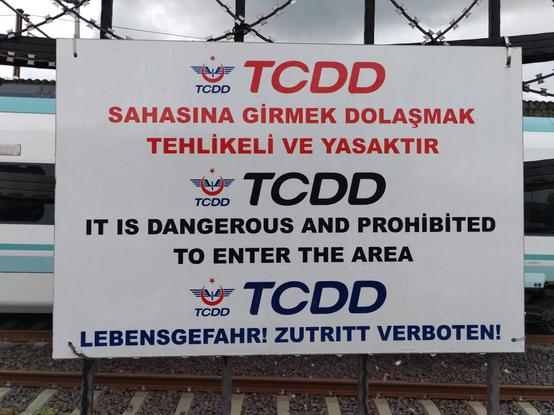 Hinweistafel auf Türkisch, Englisch und Deutsch. Auf deutsch steht der Text "Lebensgefahr! Zutritt verboten!"