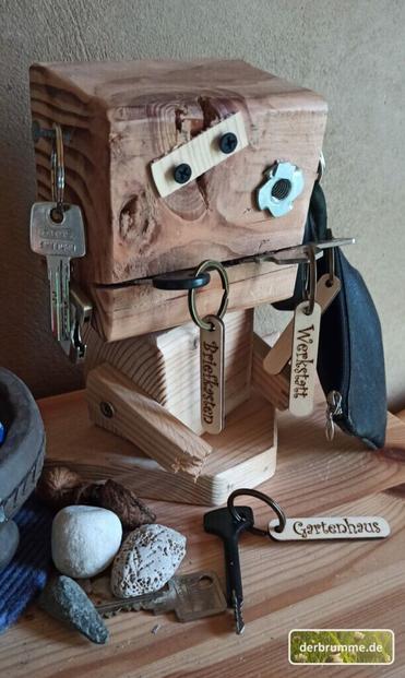 Ein aus Holzresten gebauter Roboter, der viele Schlüssel hält