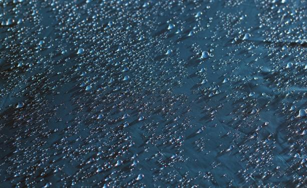 Textilie mit vielen Wassertropfen auf der Oberfläche. Ein Effekt, der durch PFAS erreicht werden kann.