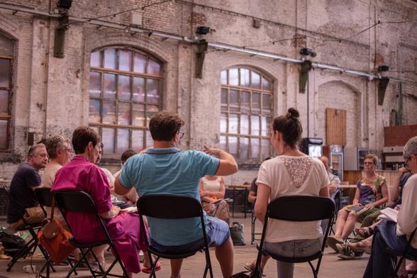 Mensen op stoelen in een grote kring in Hal5