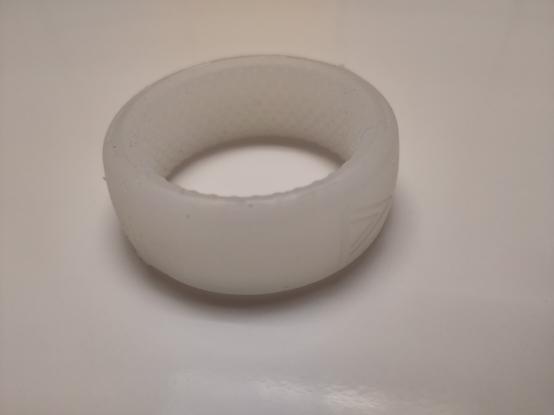 Anneau contraceptif Androswitch en silicone blanc, avec une texture sur sa face intérieure.