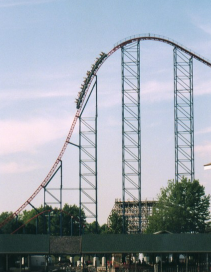 a long shot of Ride of Steel's first and biggest drop, with a train dropping down it in the image.  The picture is a bit grainy and shows the age of the photo.