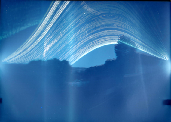 A very long exposure photo showing the paths the sun took across the sky.
The photo is blue, and white, and has light bloom everywhere and looks other-worldly.