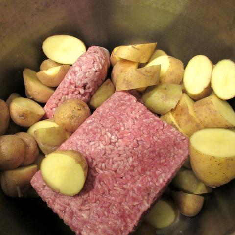 Hackfleisch und grob zerkleinerte Kartoffeln in einem Topf.
