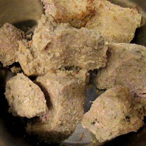 Große Brocken durchgekühlter und aufgeschnittener Hundepolenta in einem Edelstahlnapf.