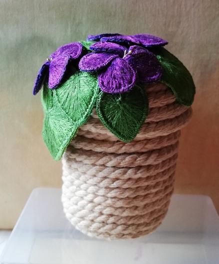 A small coiled pot made of cord is now topped with the stumpwork violets, clinging to the edge and cascading down one side.