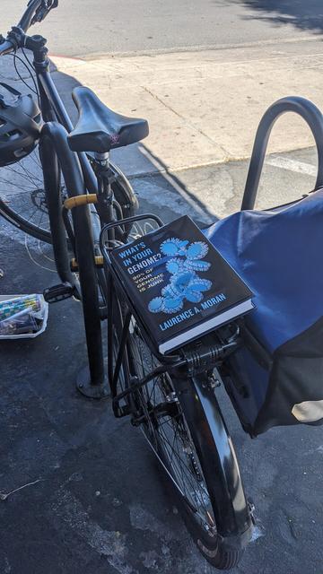 The book What's In Your Genome sitting on rack of parked bike