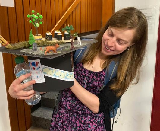 Photo of Nora Specht looking at her PhD hat.