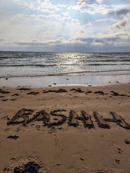 BASHH written in the sand on the beach at Llandudno whilst the sun is setting.