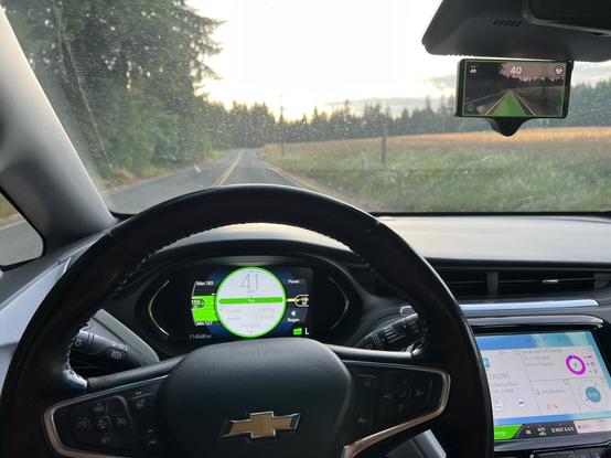 A Chevrolet bolt EV being driven down a country road by OPGM running on a comma 3