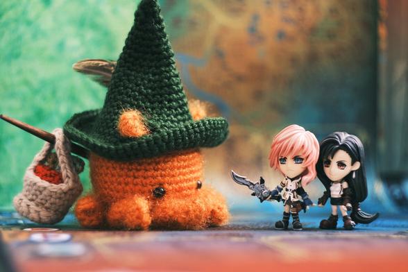 A photo a crocheted Octopuff traveler (from the Octopath traveler series), and figurines of Lighting (from Final fantasy XIII) and Tifa (from Final fantasy VII) placed facing each other as if they were engaged in an JRPG battle.