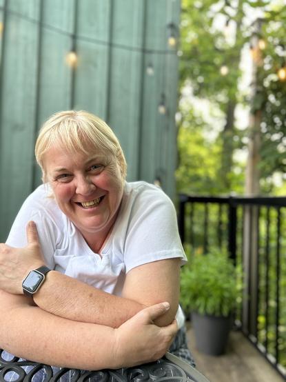 Picture of Sarah, smiling sitting on a patio.