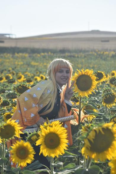 Aparezco con el cosplay de Zenitsu en un campo de girasoles junto a un girasol enorme que es del tamaño de mi cabeza