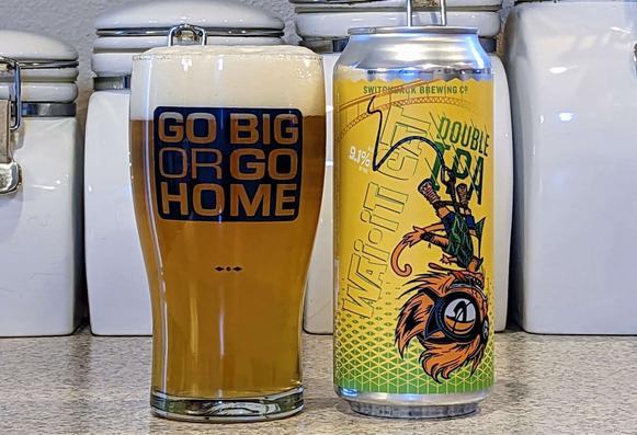 Glass and can of Wai-iti Cat Double IPA from Switchback Brewing of Burlington, Vermont. The glass has stylized text that reads, "Go big or go home"