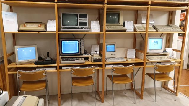 A shelf with an ABC 80, TRS-80 Model III, Apple IIe, SVI-728, Atari 1040STF, ZX Spectrum, Commodore 64, Macintosh Plus and Amiga 500