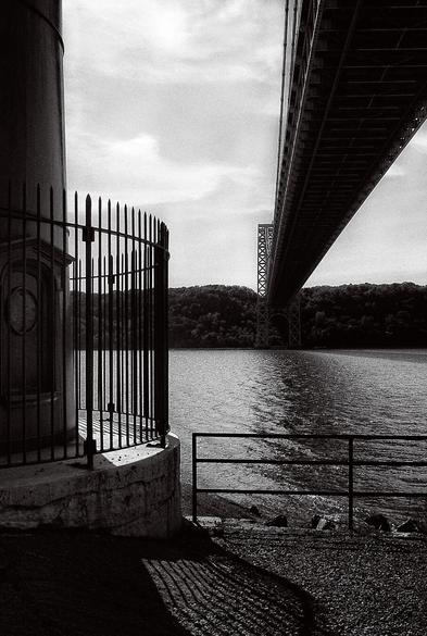 a monochromatic image from beneath the george washington bridge, on the banks of the hudson river in manhattan